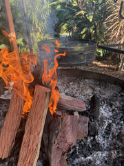 Fire burning through wooden logs with the Aussie Croc Pot in the Background