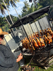 Grill with skewers of food being cooked outdoors