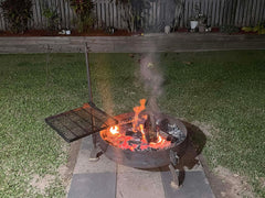 Fire pit with grill on a grassy area at night