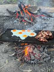Outdoor cooking over open flames, with a folding 6mm hot plate.