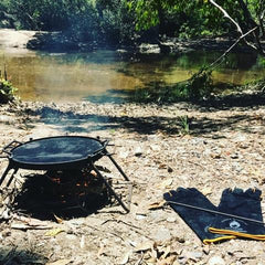 Folding BBQ grill set up at creek bed camping location